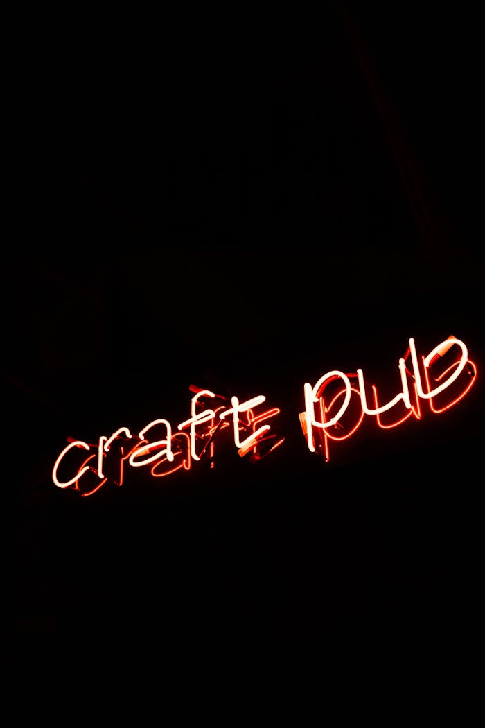 Red neon sign displaying 'craft pub' glowing in the darkness.